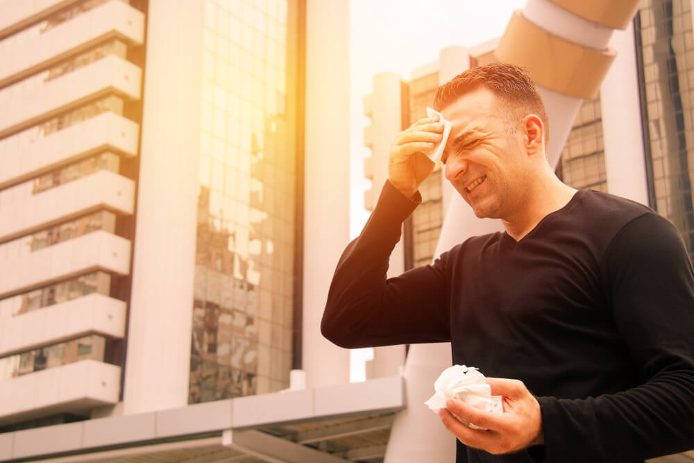 Young Man Standing Outside Can Not Stand the Hot Weather and High Temperature