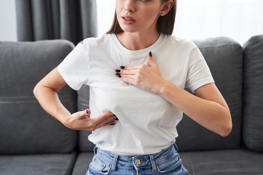 Worried Caucasian Woman Carefully Looking and Checking Breast by Herself That She Concern About Breast Cancer. 