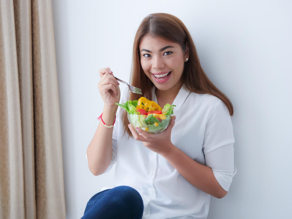 Young Asian Woman Eating Salad Vegetable in Diet Concept