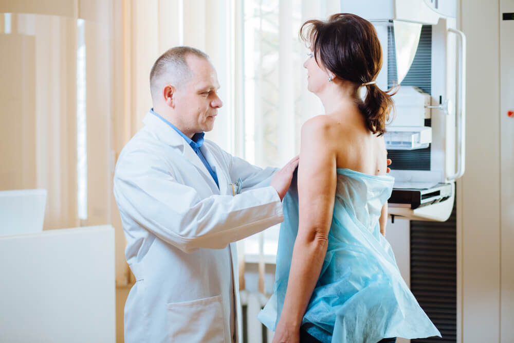 Female Patient Listens to Mammography Technologist During Survey