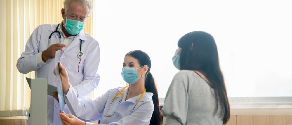 Female Doctor Looking at Mammogram Film Explain Mammogram Results