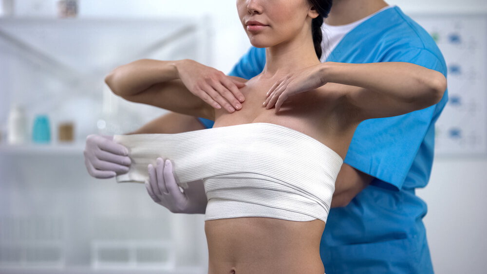 Doctor Wrapping Chest of Female Patient