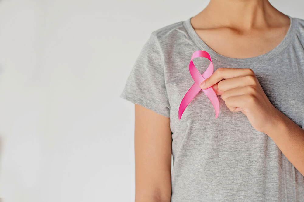 Woman Hand Holding Pink Ribbon Breast Cancer Awareness.