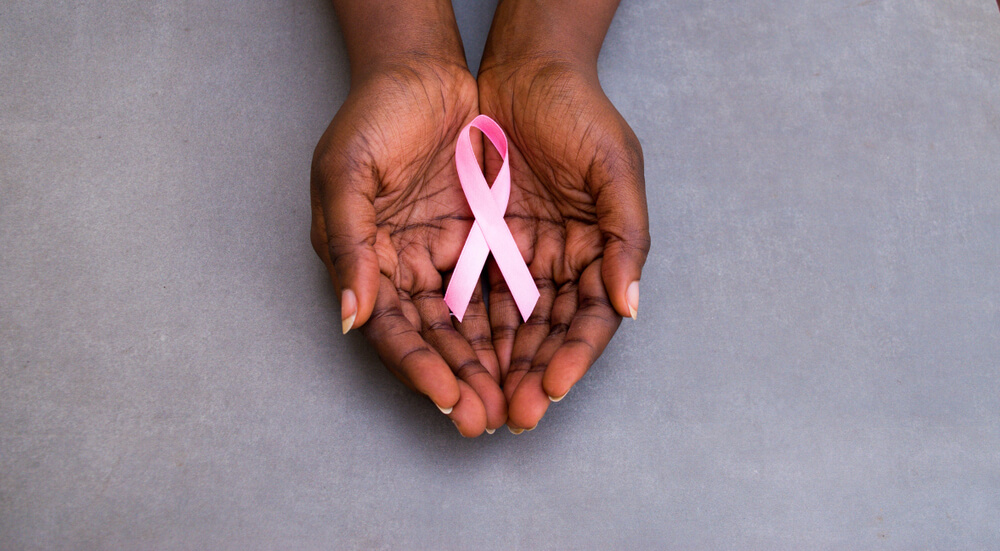Pink Ribbon Close Up in Hands for Breast Cancer