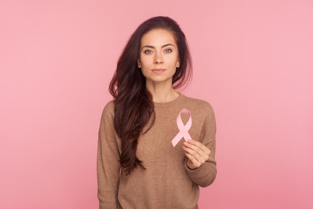 Portrait of Beautiful Young Woman With Brown Hair Holding Pink Ribbon