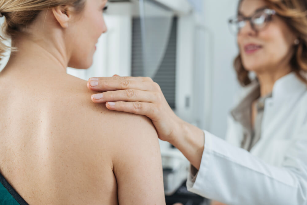 Pretty Woman Doctor Talking With Her Patient on Breast Examination