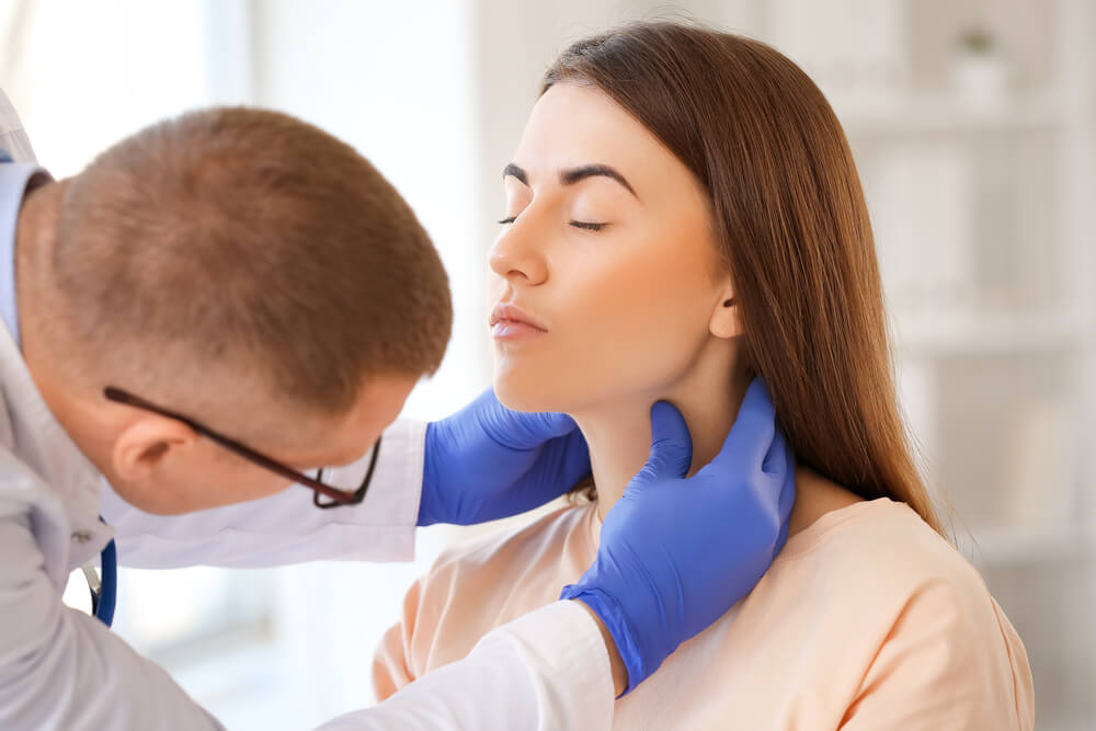 Endocrinologist Examining Throat of Young Woman in Clinic