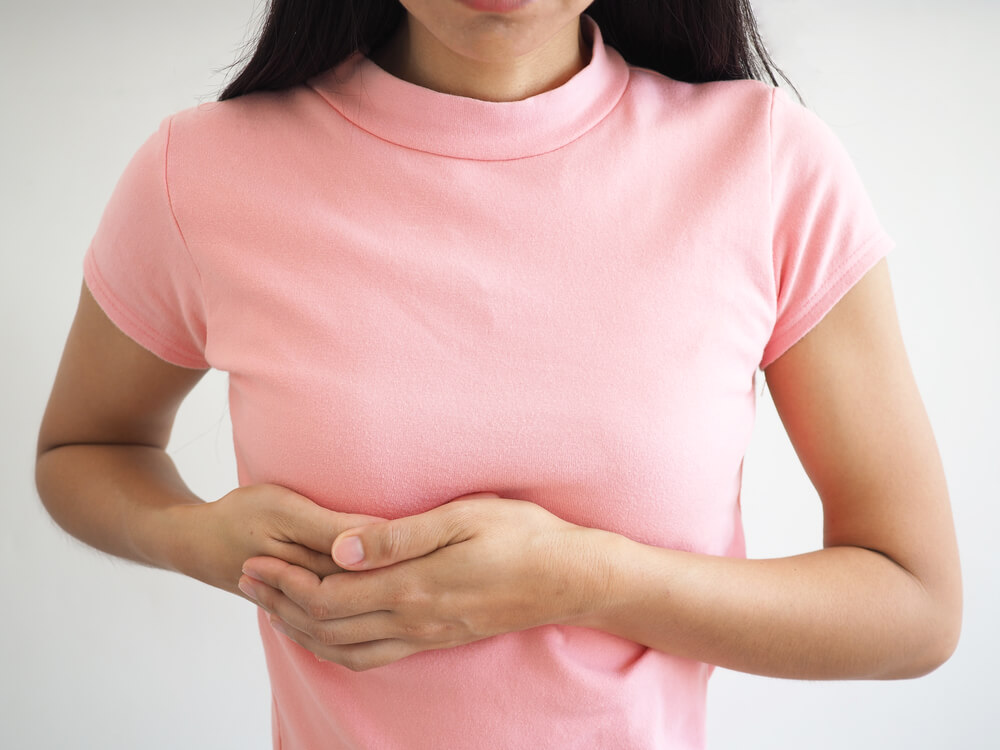 Young Woman Examining Her Breast for Lumps or Signs of Breast Cancer