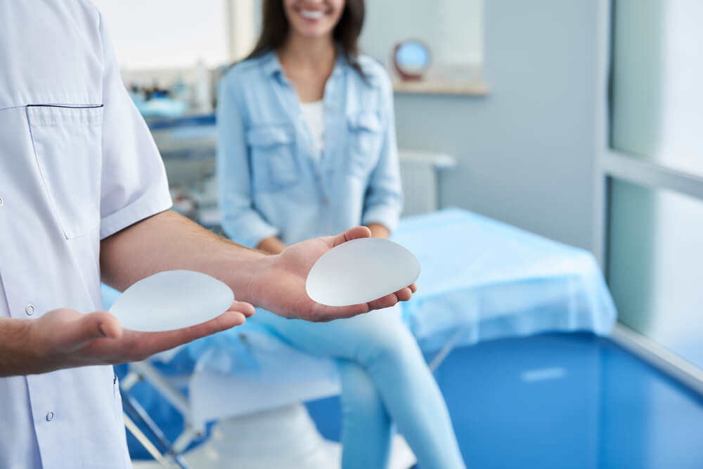 Close up Photo of Doctor Showing Silicone Implant for Woman During Consultation in Beauty Clinic