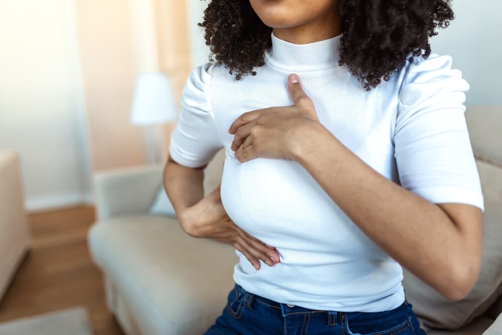 Woman Hand Checking Lumps on Her Breast for Signs of Breast Cancer.