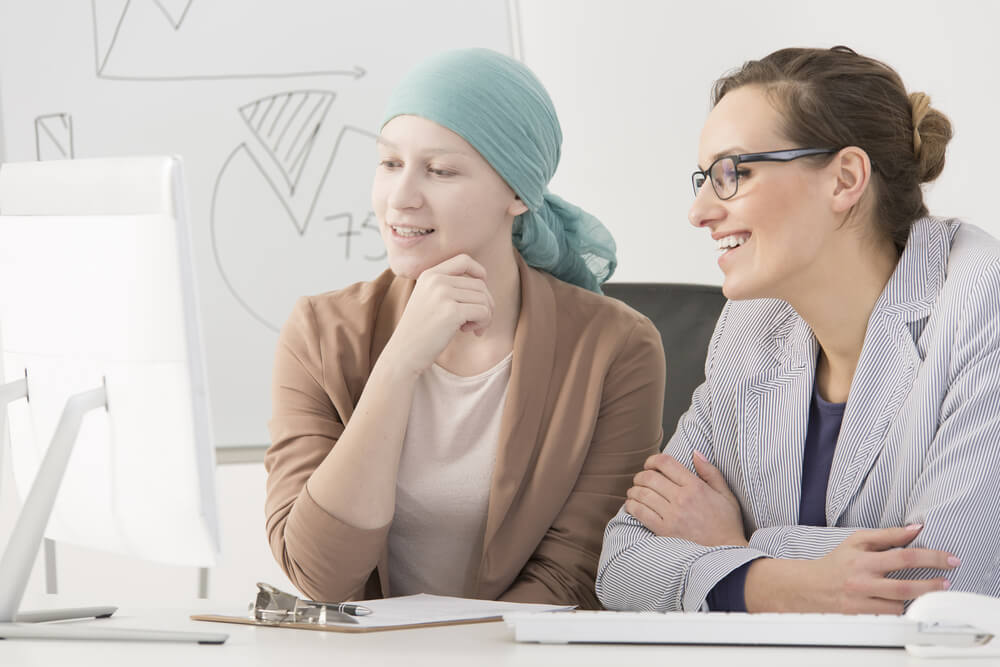 Woman With Cancer Making Re-Entering Her Job While Analyzing Statistics With a Colleague in Company