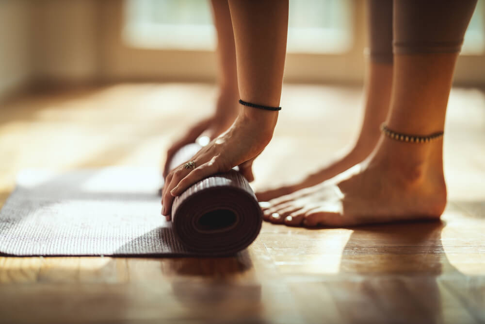 Close Up of a Womans Hands Is Rolling Up Exercise Mat and Preparing to Doing Yoga