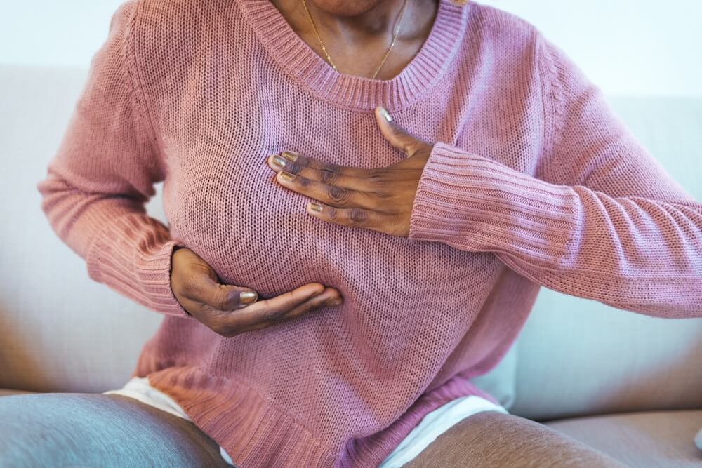 Young woman checking her breast by herself, breast health concept.