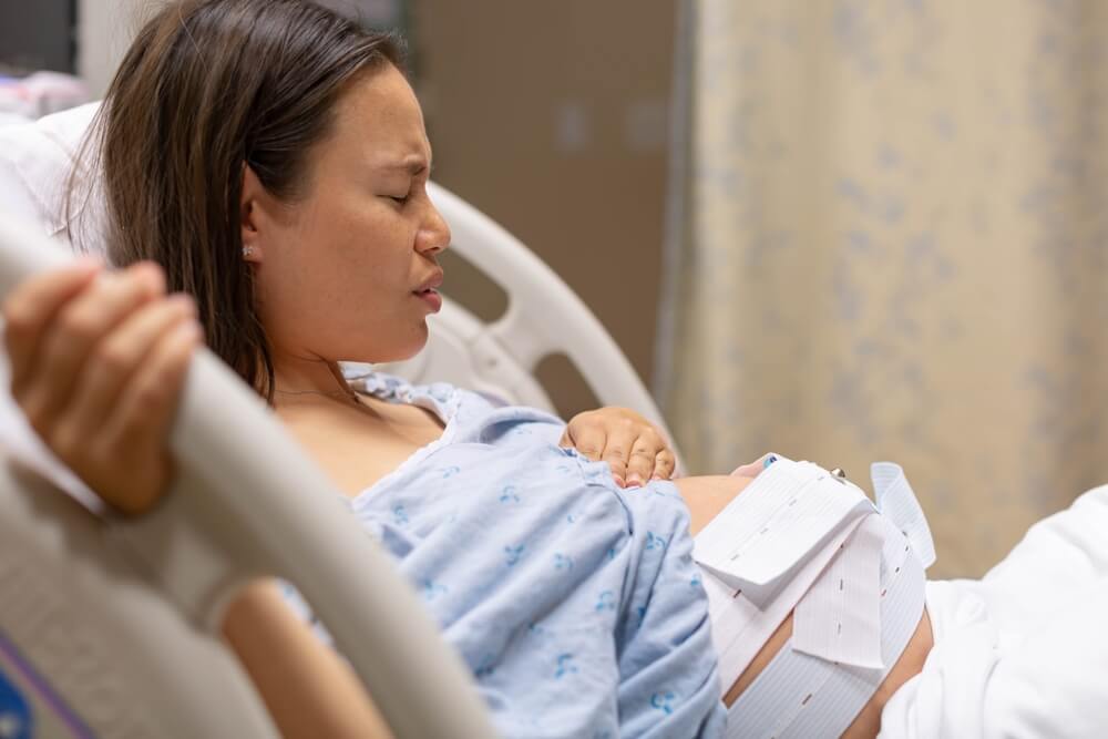 Pregnant Woman Lying In The Hospital Bed Being Monitored Before Childbirth. Induced Labor.