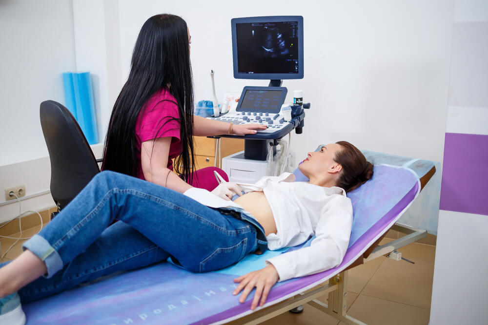 A Young Woman Lies on Her Back at the Doctor's Office While Having a Stomach Ultrasound Examination