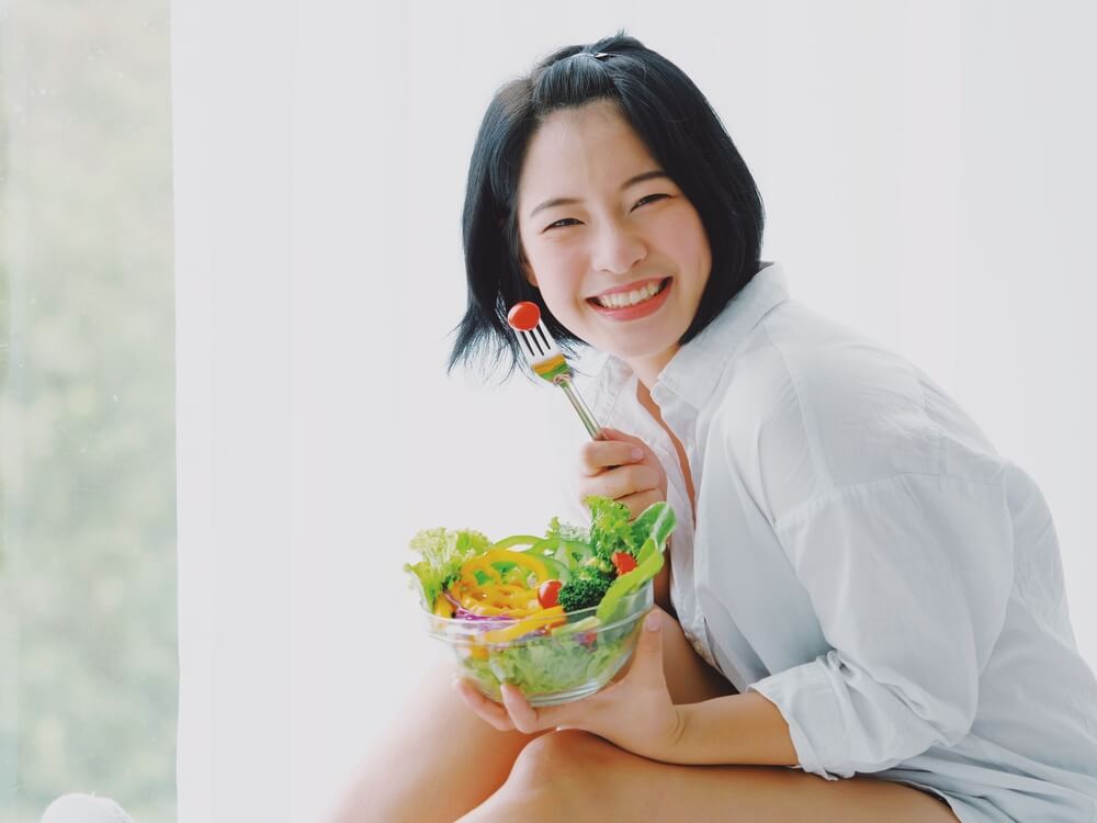 Asian Young Beautiful Woman Eating Salad With Happy Mood Smile on White Background