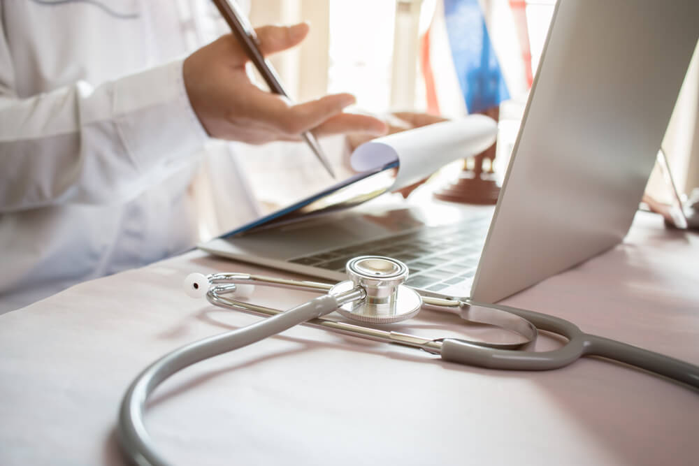 Doctor Checking Patient's Blood Pressure at Table in Office