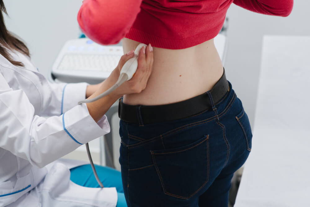 Renal Ultrasound Examination of Kidneys. Hospital Doctor Examines a Young Woman With Ultrasound.