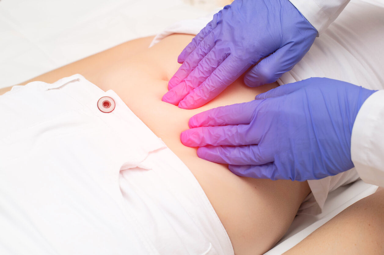 A Gynecologist Doctor Probes the Lower Abdomen of a Girl Who Has Pain and Inflammation of the Reproductive System.