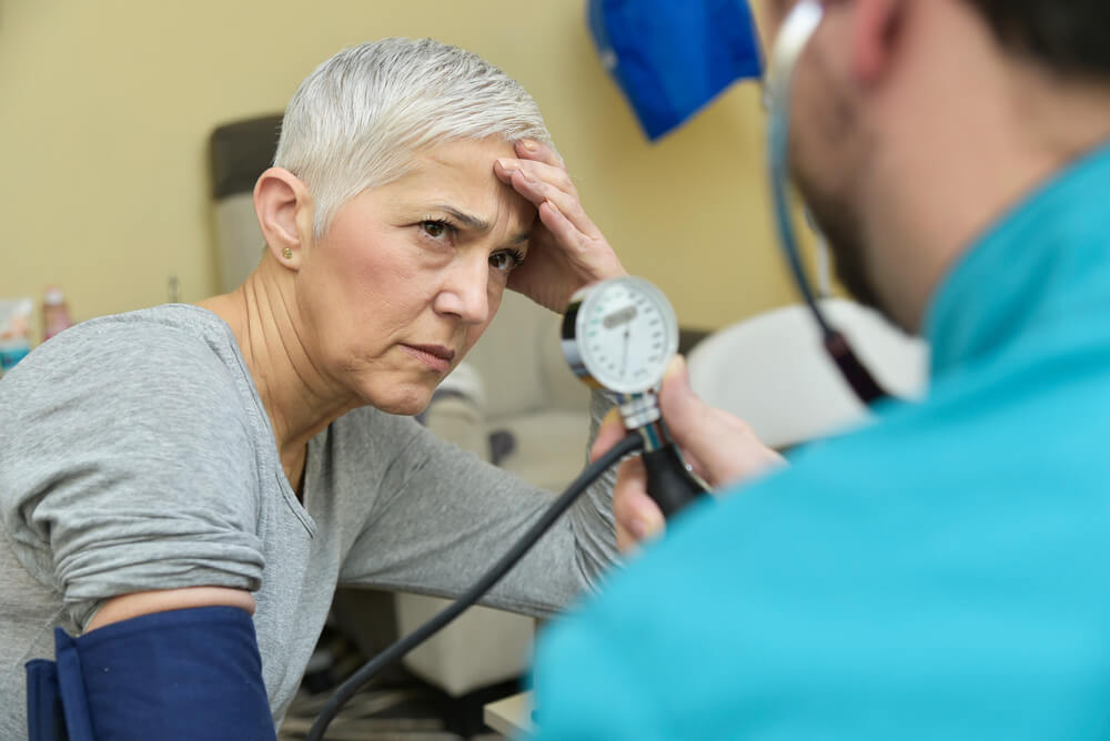 Senior Elderly Lady Receiving Bad News About Her Blood Pressure From Her Doctor or a Nurse