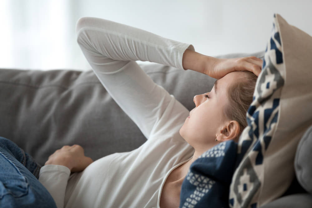 Upset Depressed Young Woman Lying on Couch Feeling Strong Headache Migraine