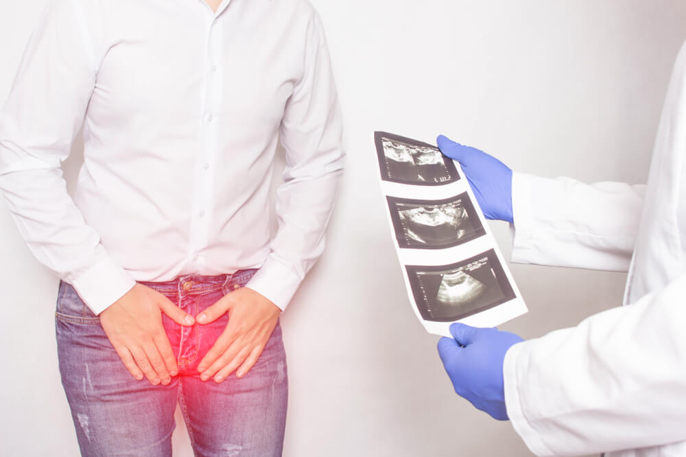 A Patient With Chronic Prostatitis and Problems With Libido at the Reception and Consultation With a Urologist Doctor Who Is Holding Ultrasound Diagnostic Images