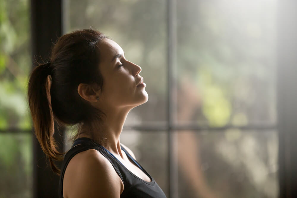 Profile Portrait of Young Attractive Yogi Woman Breathing Fresh Air, Her Eyes Closed, Meditation Pose, Relaxation Exercise