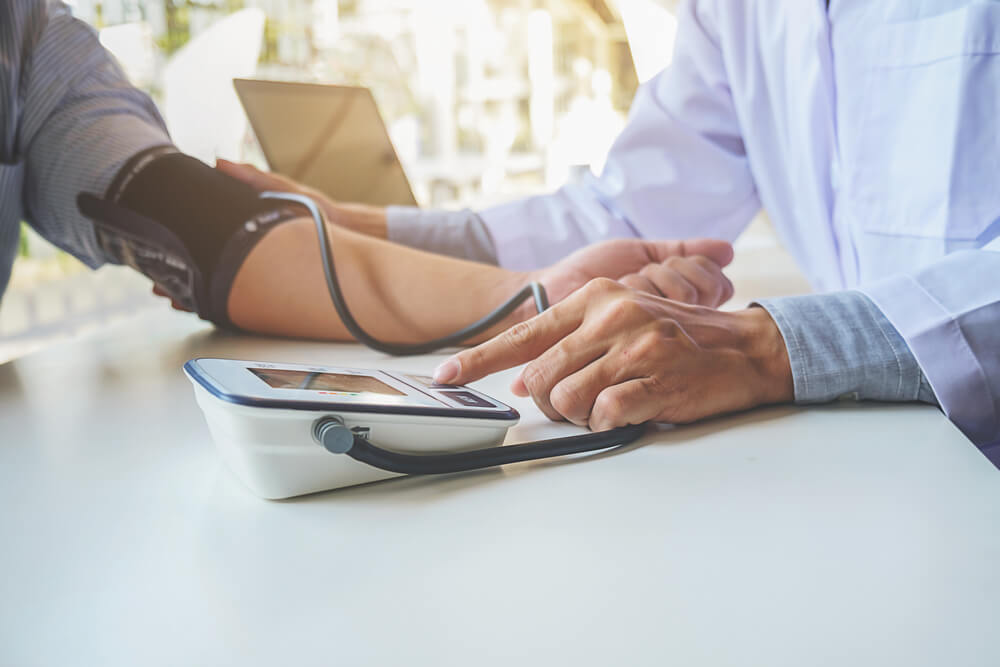 Healthcare, Hospital and Medicine Concept - Doctor and Patient Measuring Blood Pressure.