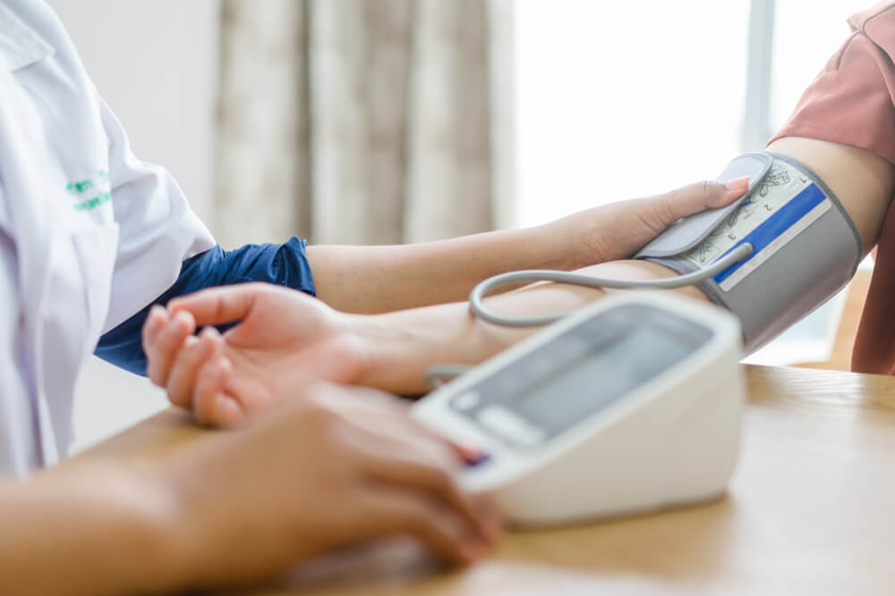 Healthcare, Hospital and Medicine Concept - Doctor and Patient Measuring Blood Pressure.