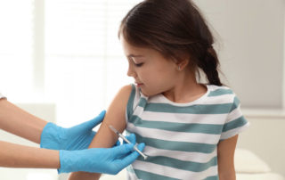 Doctor Vaccinating Little Child in Modern Clinic