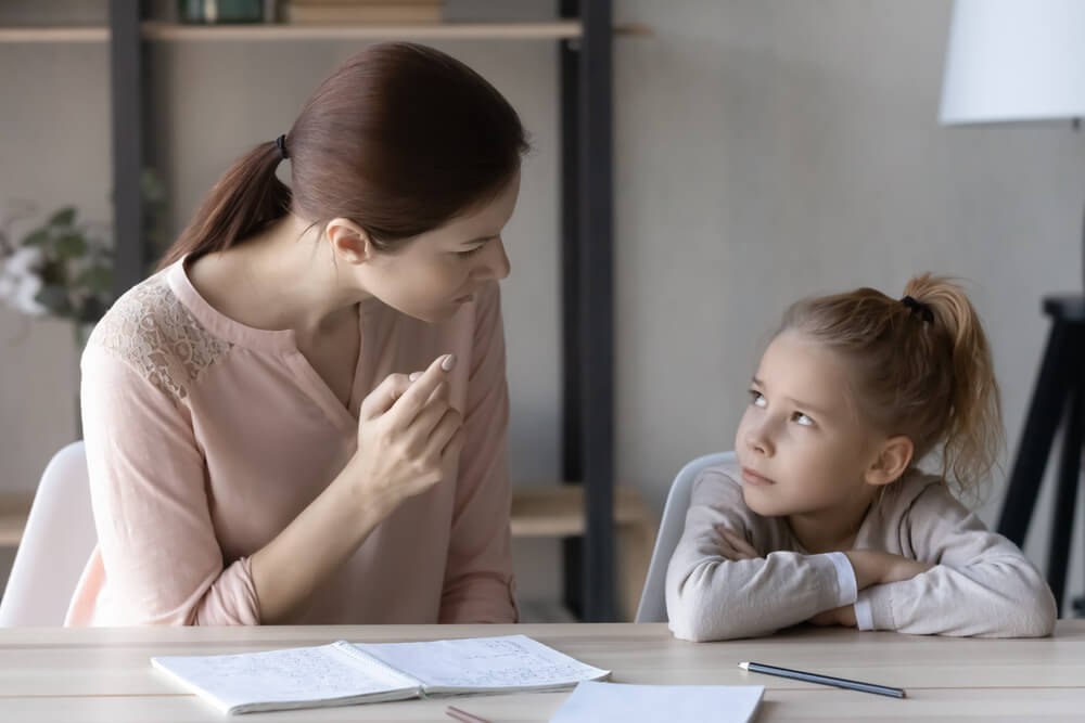 Authoritative Mother Studying With Little Schoolgirl Daughter