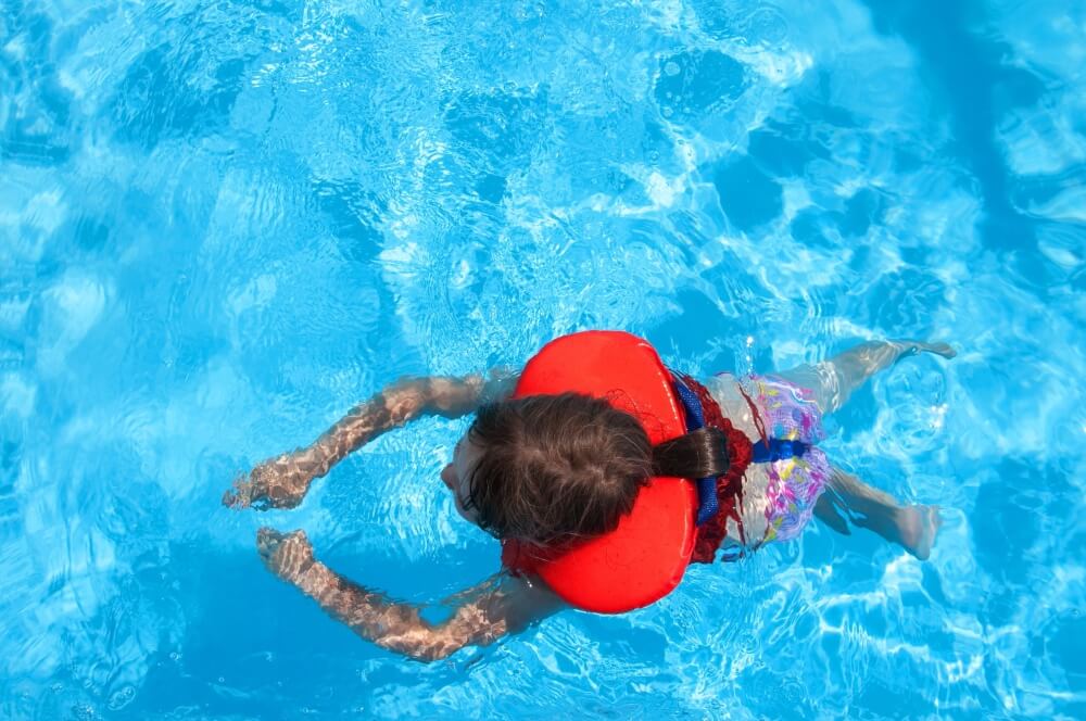 A Child Swimming in the Swimming Pool Wearing Life Jacket