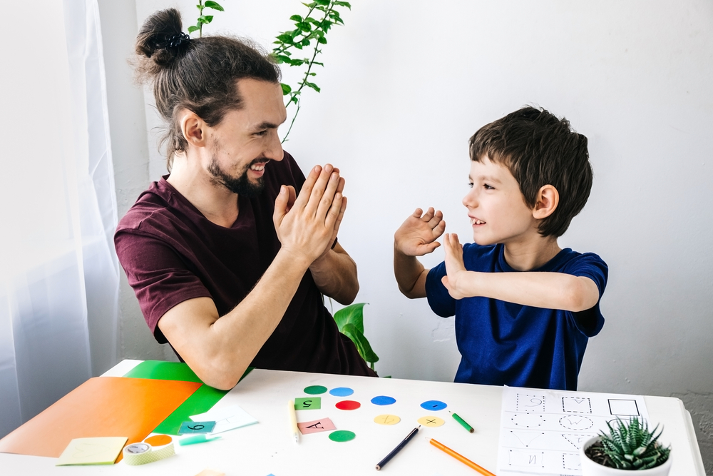 Happy Autism Boy During Therapy With School Counselor Learning And Having Fun