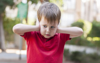 Little,Caucasian,Boy,In,Red,Polo,Shirt,Closing,Ears,With