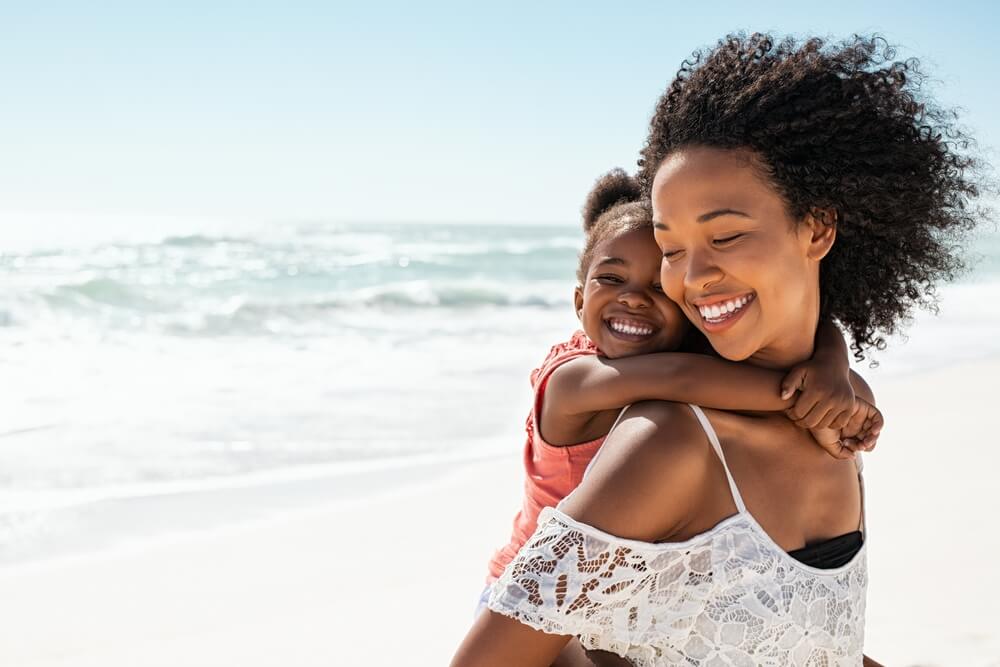 Smiling Young Black Mother and Beautiful Daughter Having Fun on the Beach