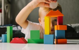 Game Colored Geometric Shapes Children Close-up on the Table and the Child Plays Selective Focus