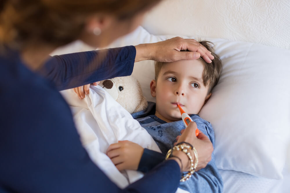 Sick Boy With Thermometer Laying In Bed And Mother Hand Taking Temperature