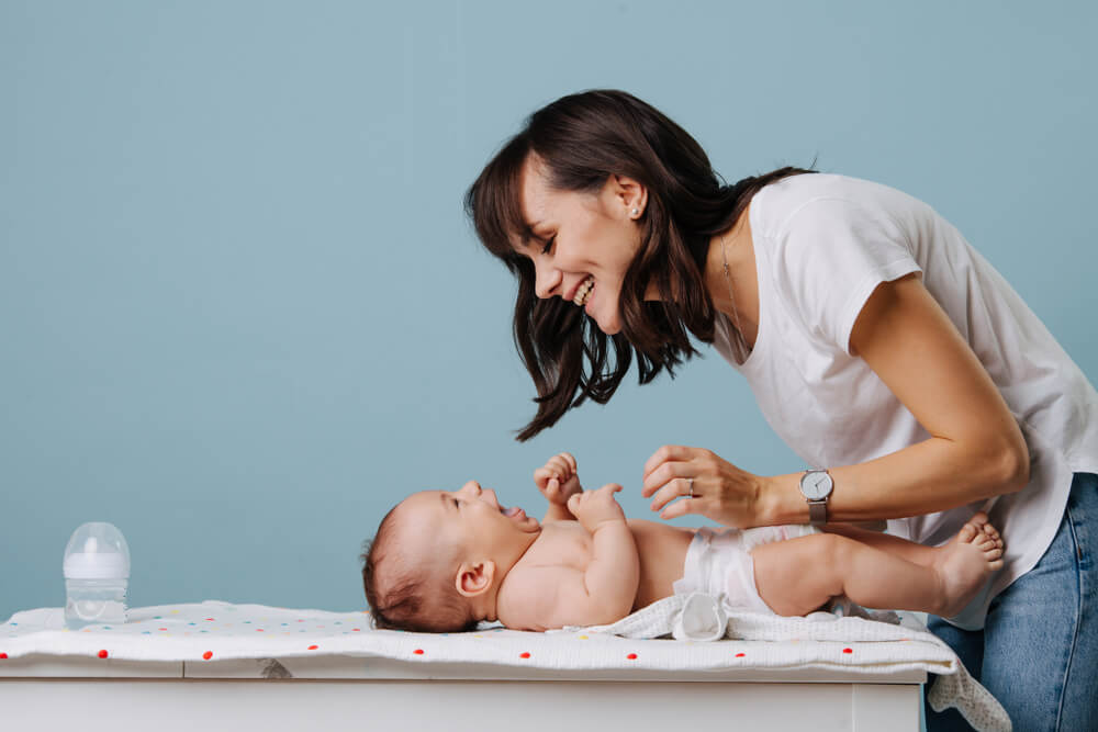 Mother changing diaper on her baby.