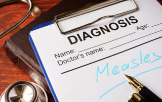 Medical form with the diagnosis of Measles on a table.
