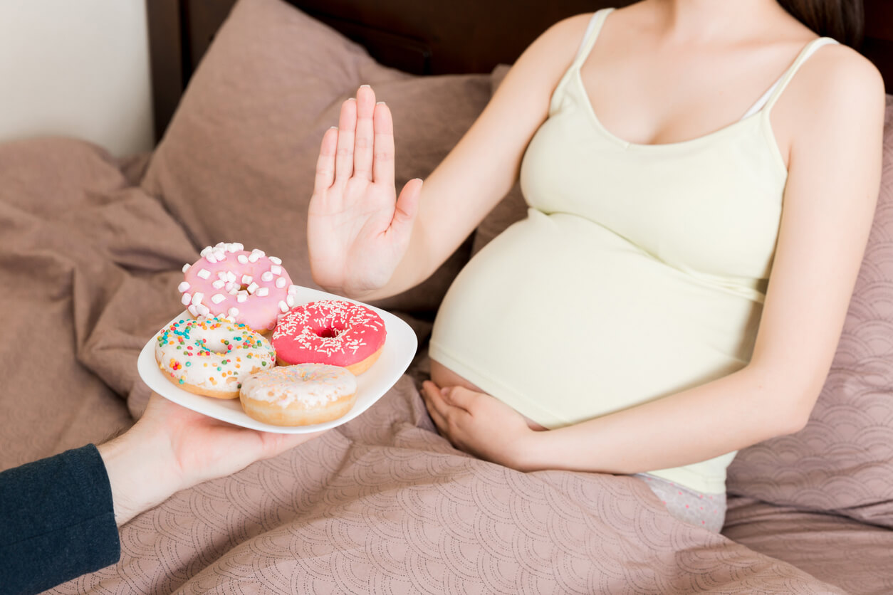 Pregnant Woman Staying In Bed Rejects to Eat Junk Food Such as Donuts and Makes No Gesture