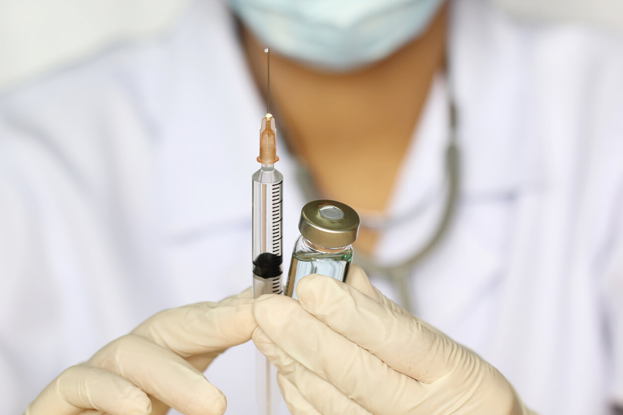 Doctor Hand Holding Draw Syringe and Medicine Bottle on White Background