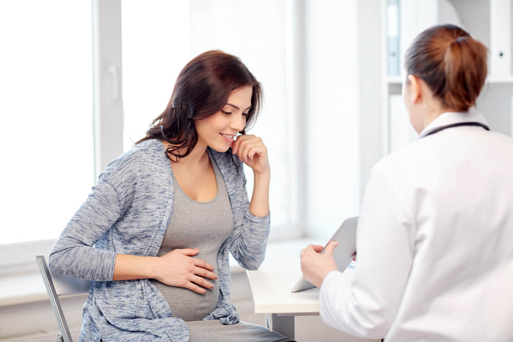 Gynecologist Doctor With Tablet PC Computer and Pregnant Woman Meeting at Hospital