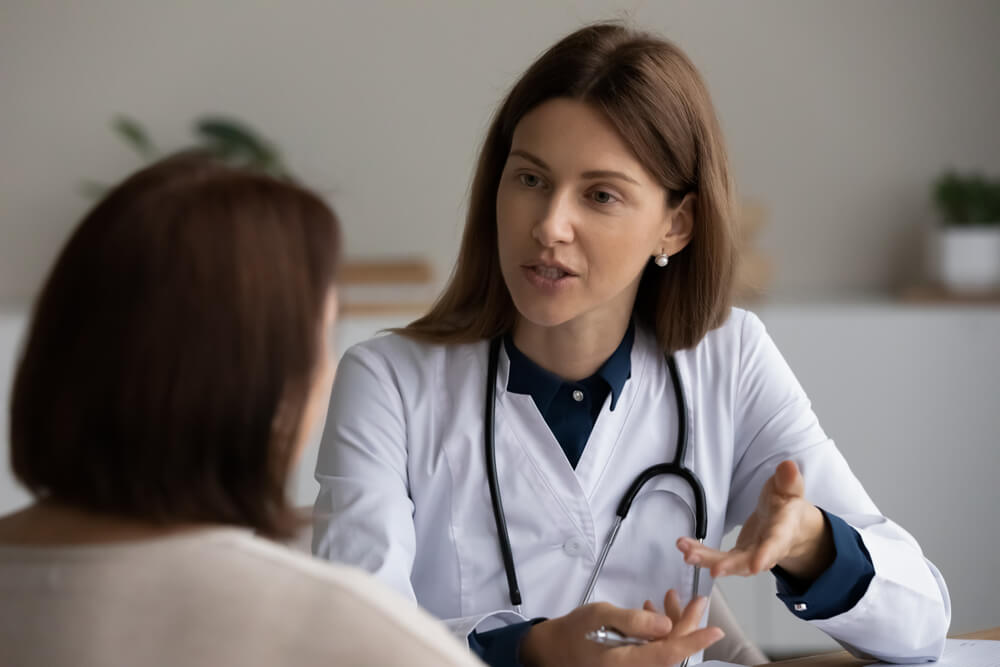 Young Female Physician Asking Older Patient About Complaints, Instructing About Treatment