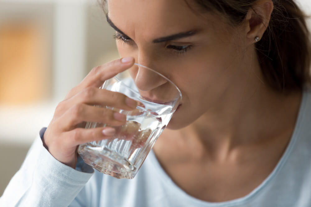 Close up Sick Young Woman Holds Glass, Unhealthy Female Feeling Thirsty Drinking Still Clear Water Preventing of Dehydration Normally Function in Body and Clear Toxins.