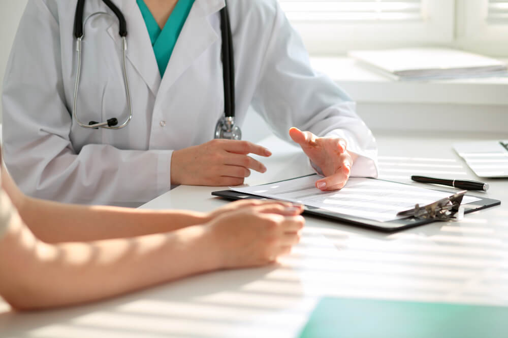 Doctor and Patient Are Discussing Something, Just Hands at the Table