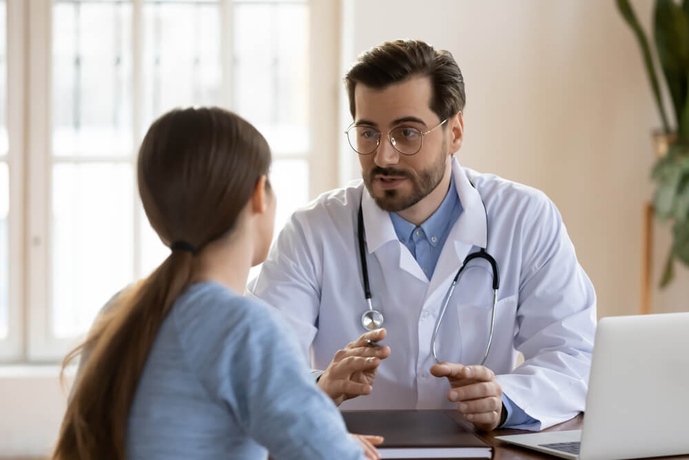 Serious Caucasian Male Doctor in White Medical Uniform Talk Discuss Results or Symptoms With Female Patient