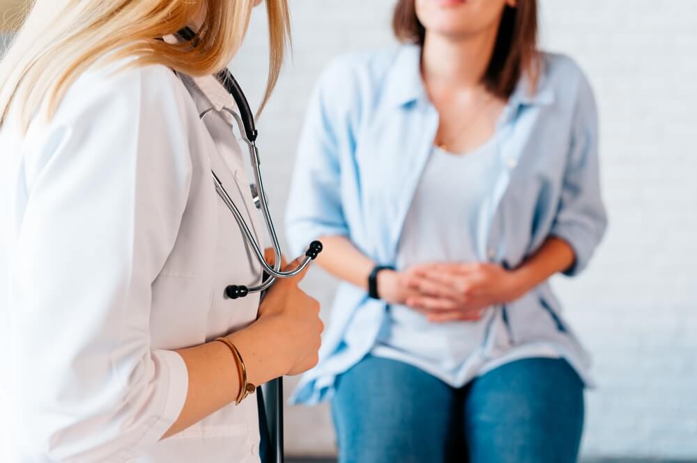 A Woman in Consultation With a Doctor With Abdominal Pain. It Is a Painful Menstrual Period or Bladder