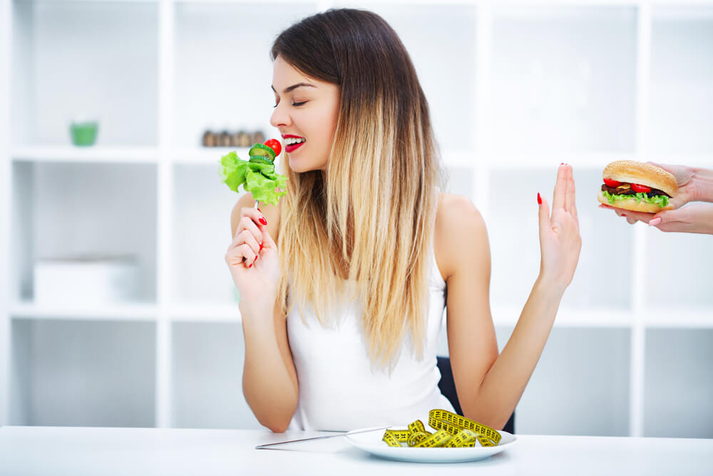 Dieting Concept, Beautiful Young Woman Choosing Between Healthy Food and Junk Food