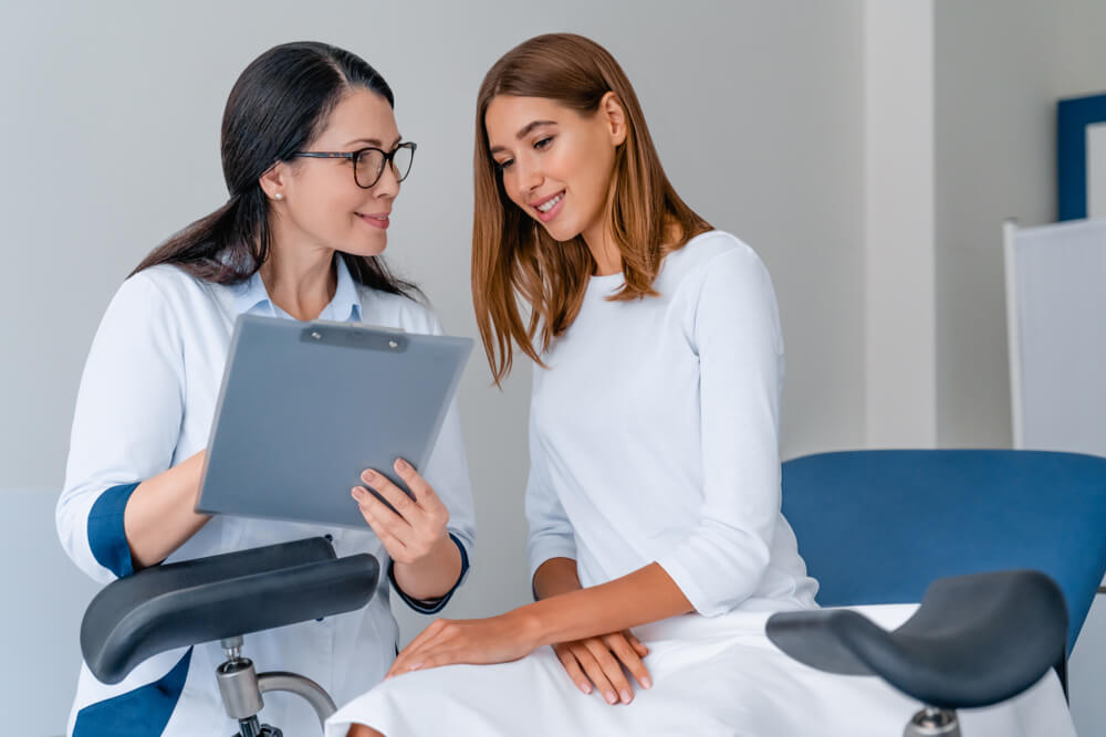 Adult Smiling Female Gynecologist Working With Patient