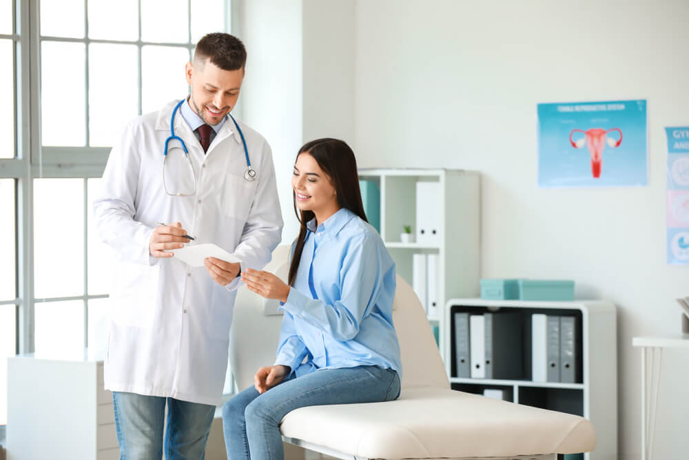 Male Gynecologist Working With Woman in Clinic